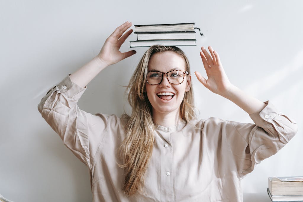 Happy student with heap of books on head