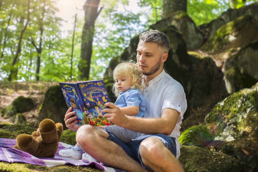 Photo Of Man And Child Reading Book During Daytime