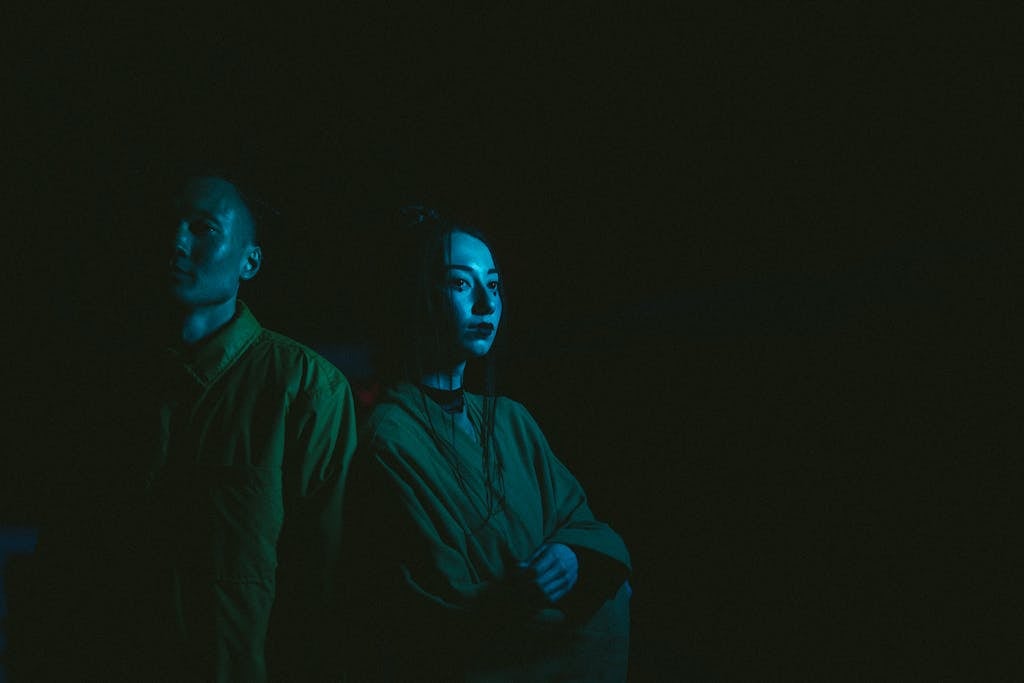 Photo Of Man And Woman With Blue Light Reflection On Black Background